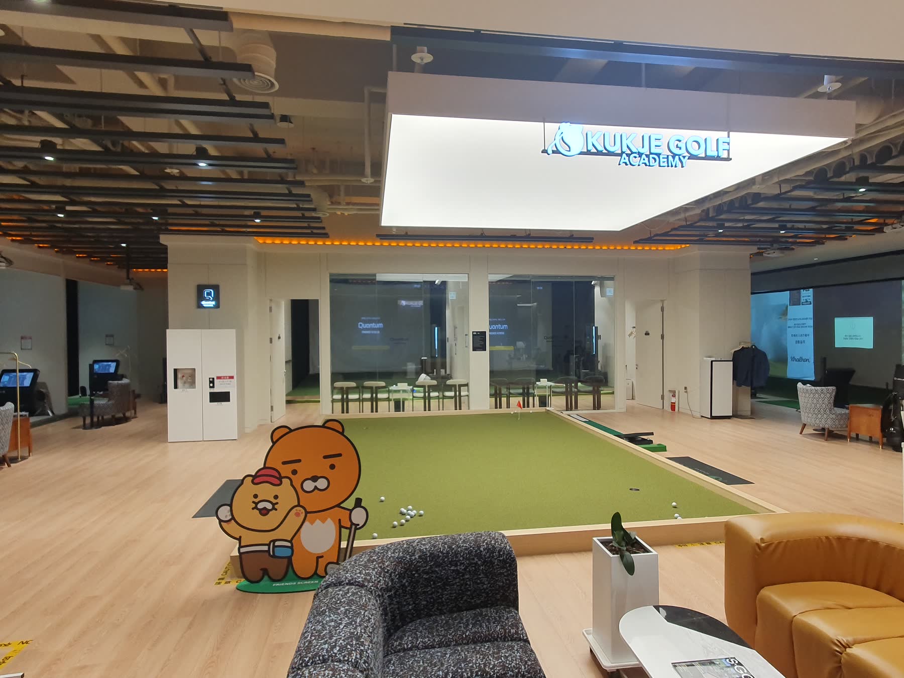 KUKJE GOLF ACADEMY 간판 아래 실내 퍼팅장과 라운지
